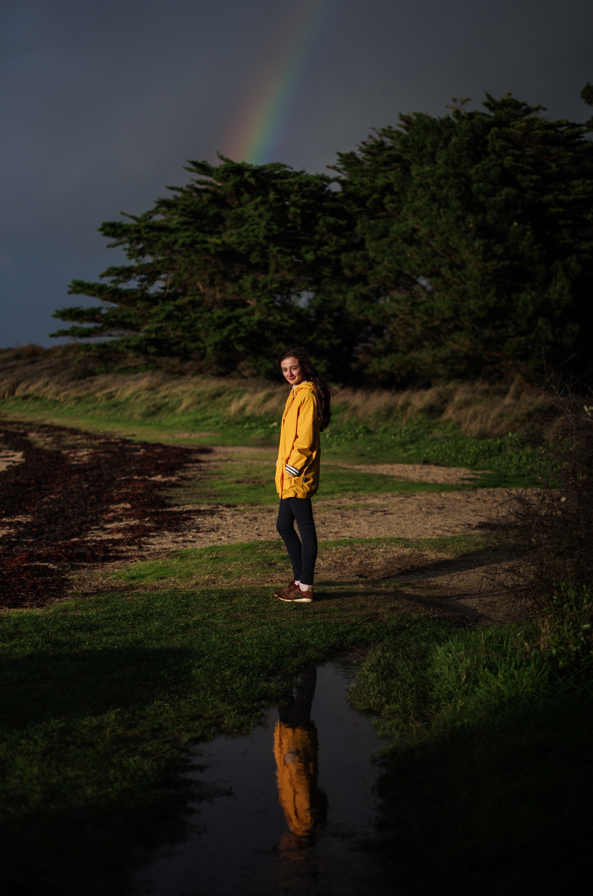 Promeneur dans un paysage breton sous un arc-en-ciel