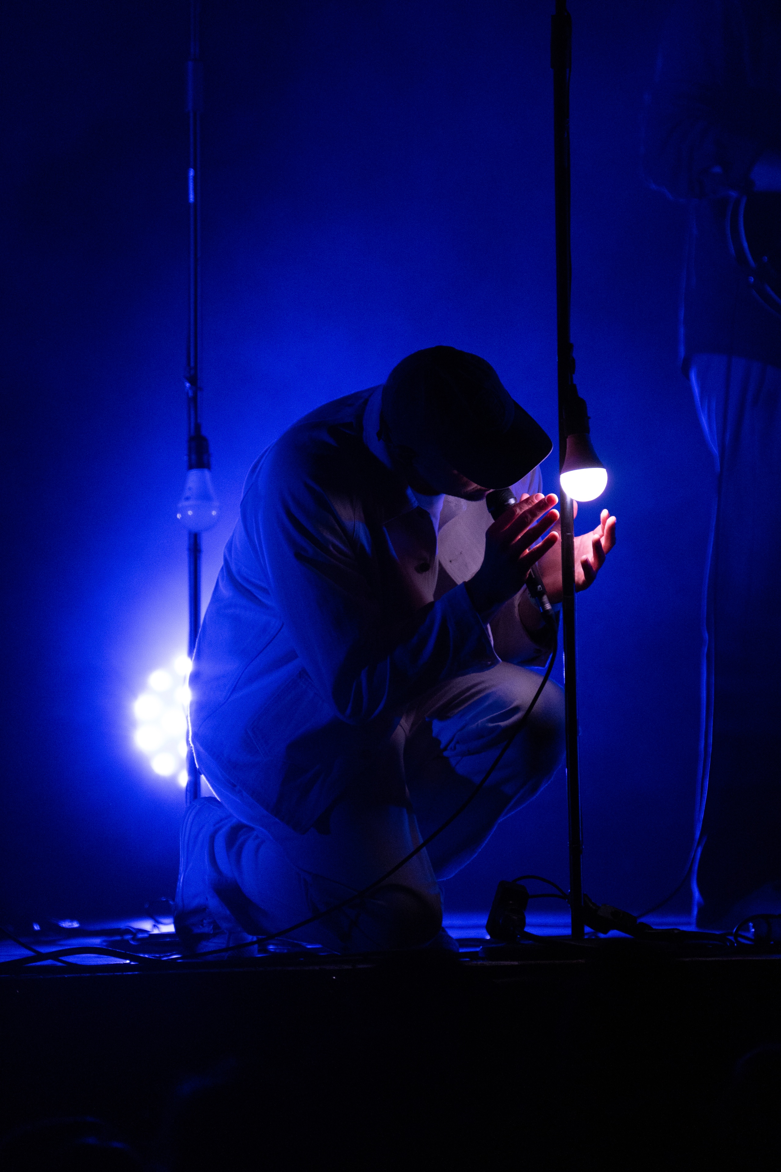 Artiste sur scène pendant un concert, dans une lumière contrastée
