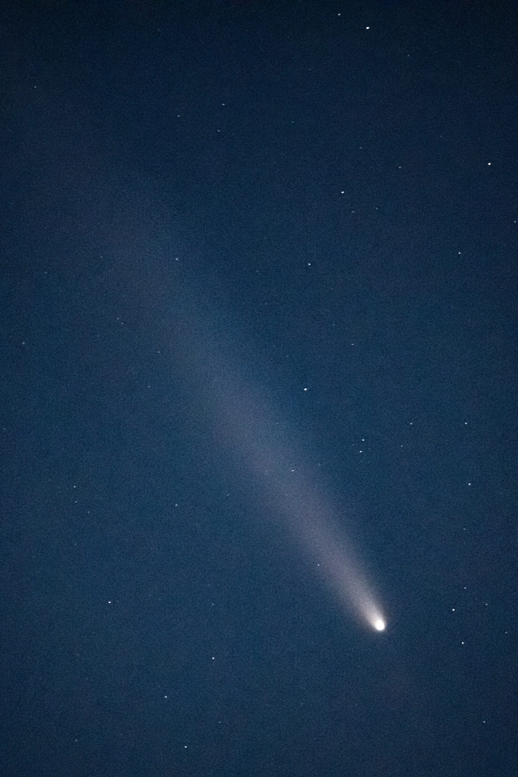 Comète traversant un ciel étoilé bleu profond